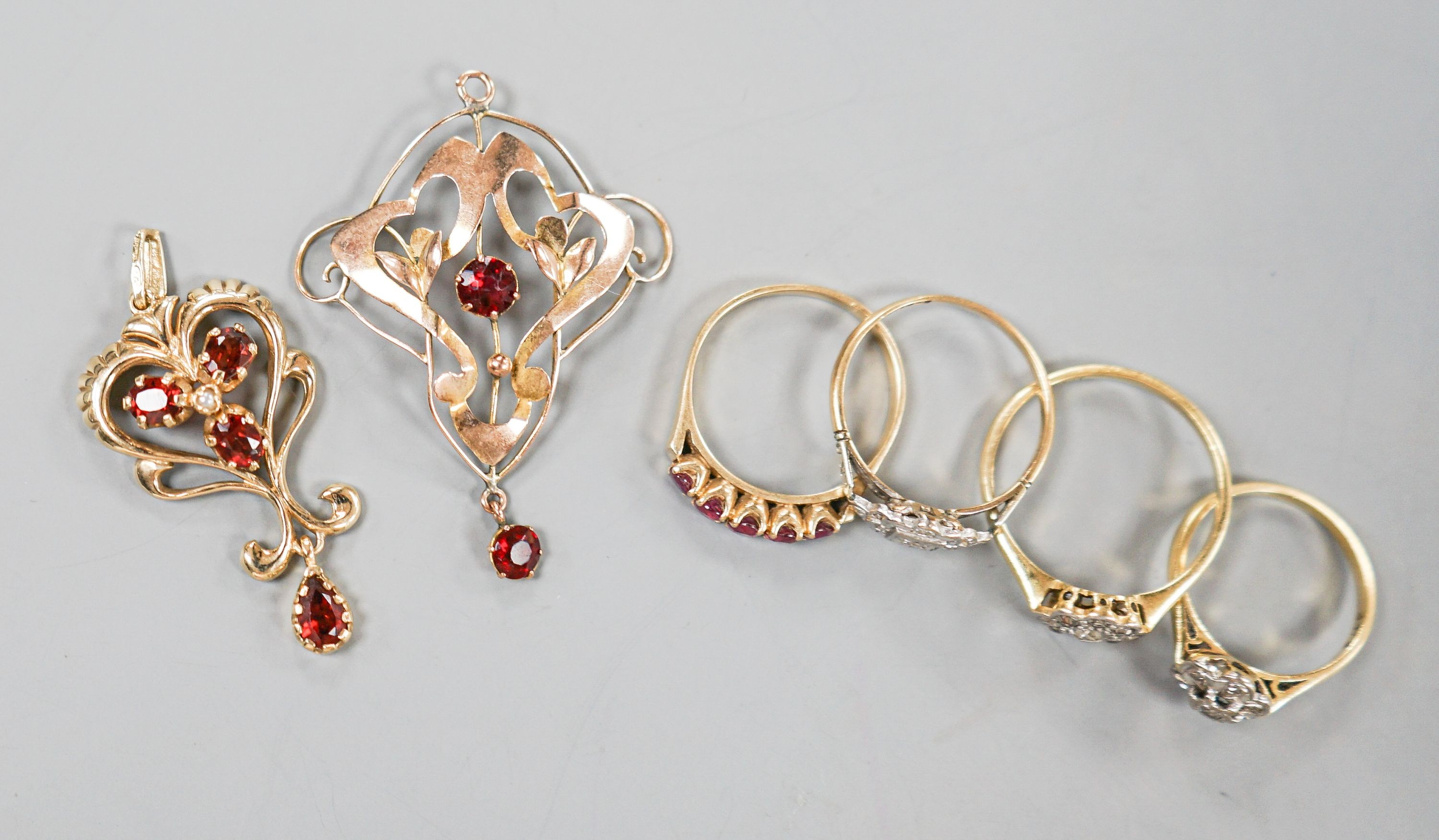 Two 18ct and diamond cluster rings, gross 5.3 grams, a 585 and diamond chip ring, gross 1.7 grams, a 9ct gold gem set ring and two 9ct pendants, gross 8.9 grams.
